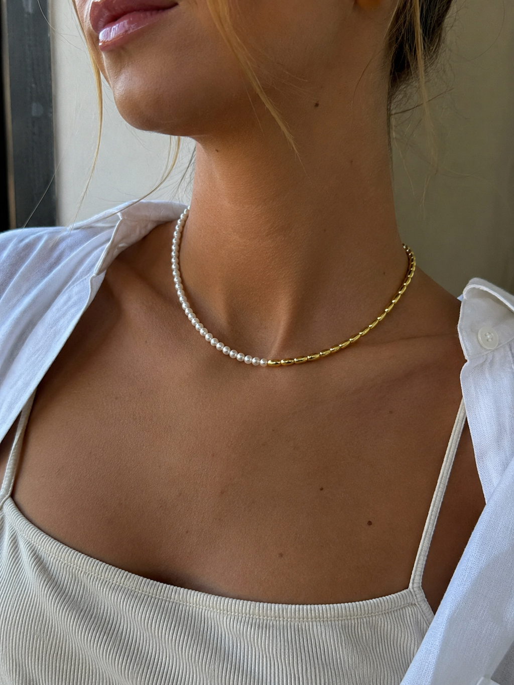 Woman wearing Marbs freshwater pearl necklace with gold bead detailing by Joi Jewels 