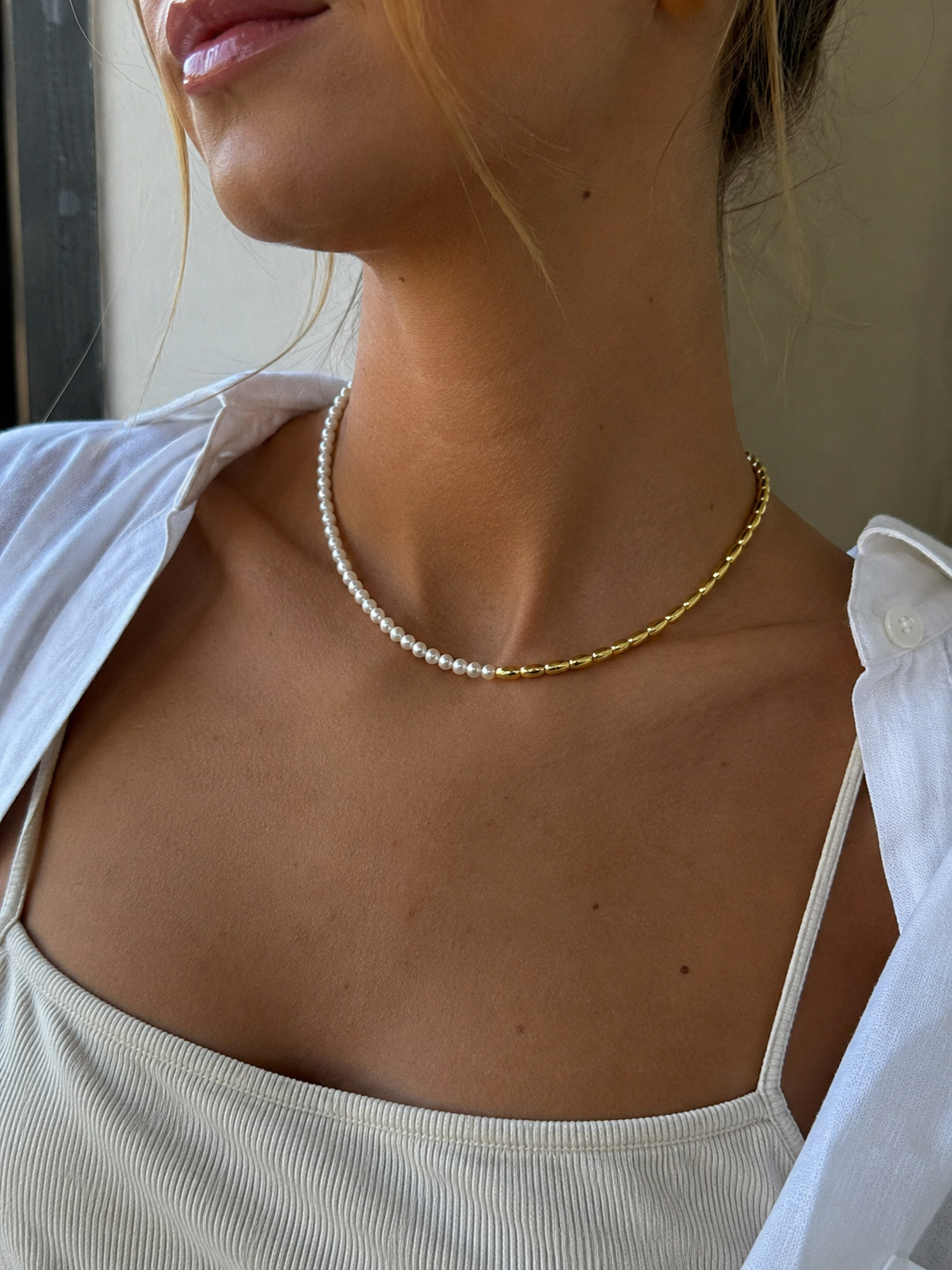 Woman wearing Marbs freshwater pearl necklace with gold bead detailing by Joi Jewels 