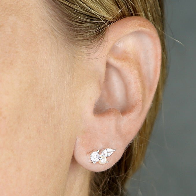 Leah sterling silver pearl and cubic zirconia cluster stud earrings worn on an ear